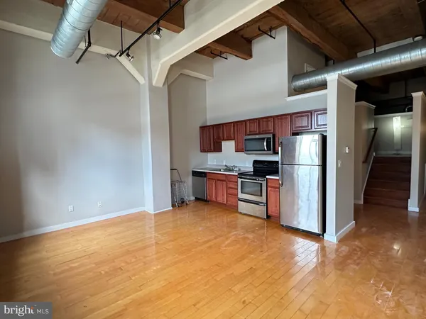 a view of a kitchen with stainless steel appliances wooden floor and a kitchen