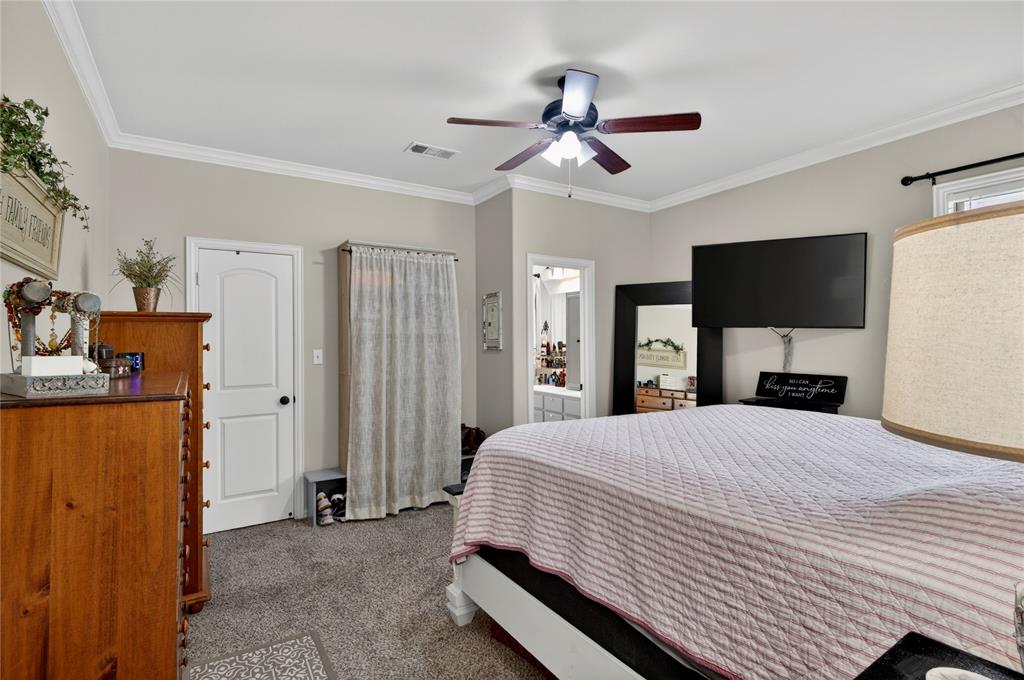 701 West Lamberth Road Sherman, TX 75092 - Photo 23 of 37 Neutral-toned walls with crown molding, wood-finish ceiling fan with integrated lighting, and carpet flooring