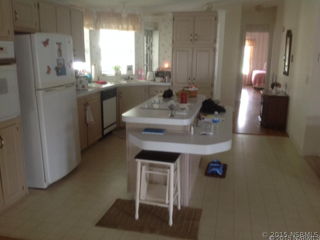 744 Navigators Way Edgewater, FL 32141 - Photo 2 of 6 a kitchen with kitchen island a sink stove and refrigerator