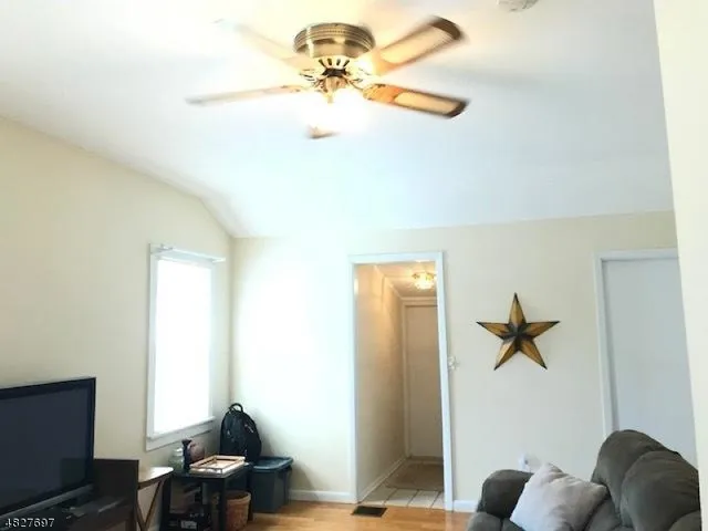 a a room with a chandelier fan and windows