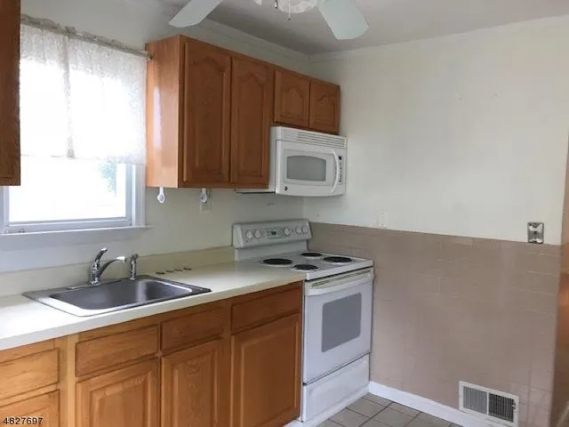 a kitchen with stainless steel appliances granite countertop a sink stove and microwave