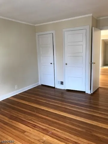 a view of a room with wooden floor and white doors