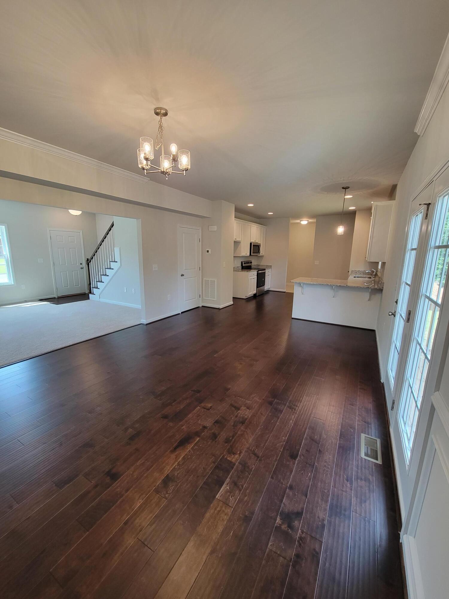 4933 Warrior Drive Salem, VA 24153 - Photo 2 of 11 an empty room with wooden floor and staircase