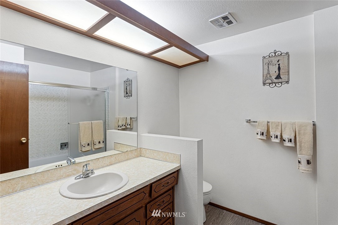 16418 Southeast 145th Street Renton, WA 98059 - Photo 19 of 25 a bathroom with a granite countertop sink a toilet and a mirror