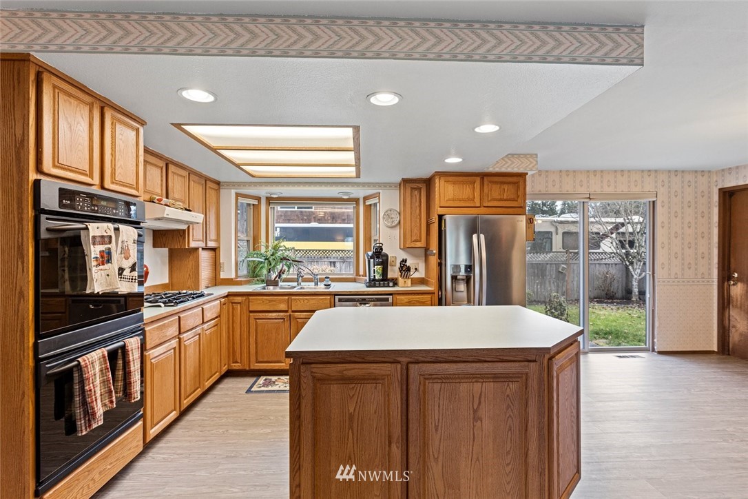 16418 Southeast 145th Street Renton, WA 98059 - Photo 3 of 25 a kitchen with stainless steel appliances a sink stove and refrigerator