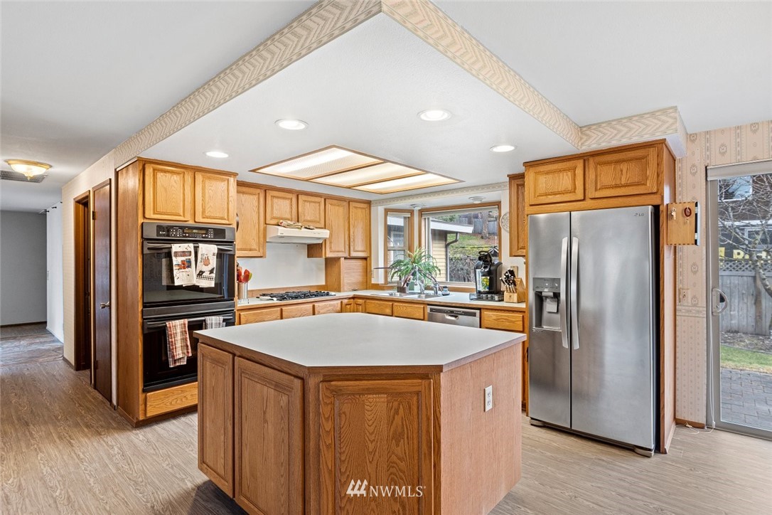 16418 Southeast 145th Street Renton, WA 98059 - Photo 4 of 25 a kitchen with stainless steel appliances granite countertop a refrigerator a sink and a stove
