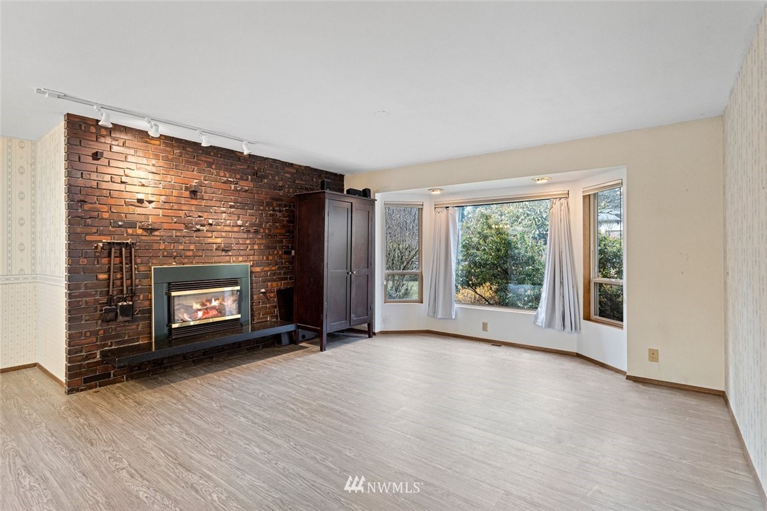 16418 Southeast 145th Street Renton, WA 98059 - Photo 8 of 25 a view of an empty room with a fireplace and a window