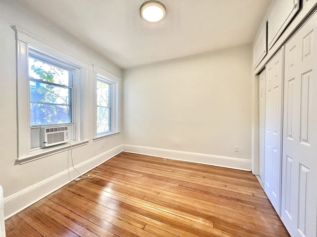 6 Parkway Brookline Ma, Unit 2 Brookline, MA 02445 - Photo 7 of 10 a view of an empty room with wooden floor and a window