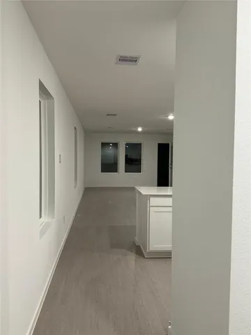 a view of a big room with wooden floor and windows