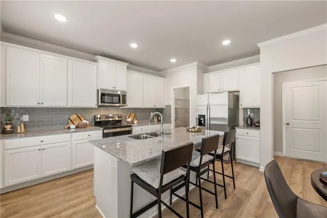 a kitchen with white cabinets and stainless steel appliances