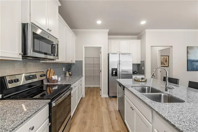 a kitchen with stainless steel appliances granite countertop a sink stove and refrigerator
