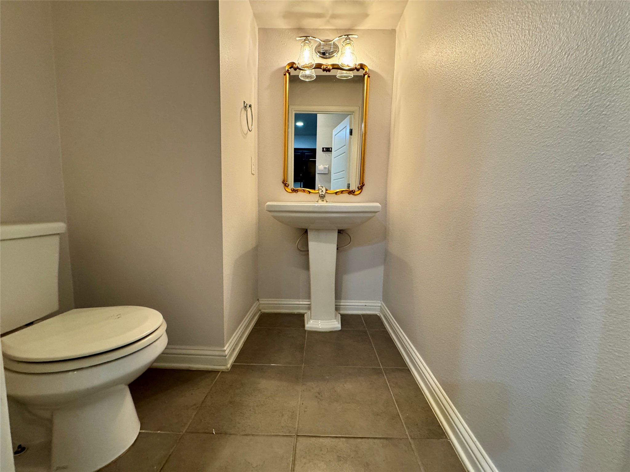 6814 East Riverside Drive, Unit 25 Austin, TX 78741 - Photo 11 of 26 Half bathroom with dark tile patterned floors and baseboards