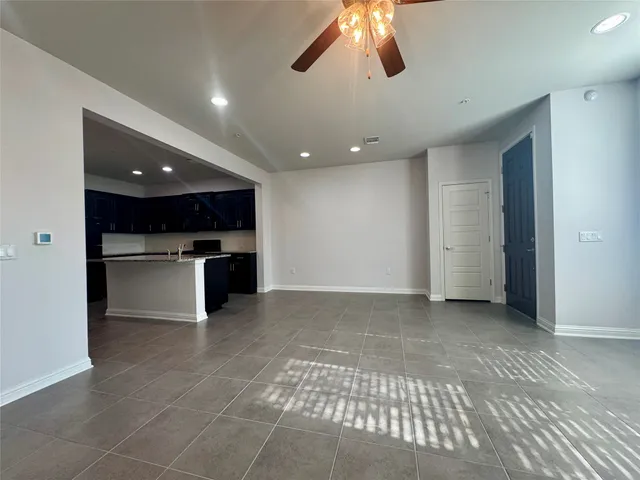 a view of a kitchen with a sink and an empty room