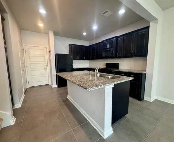 a kitchen with stainless steel appliances granite countertop a refrigerator and a sink