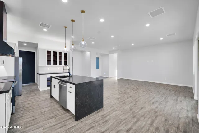 a kitchen with stainless steel appliances granite countertop a stove and a wooden floors