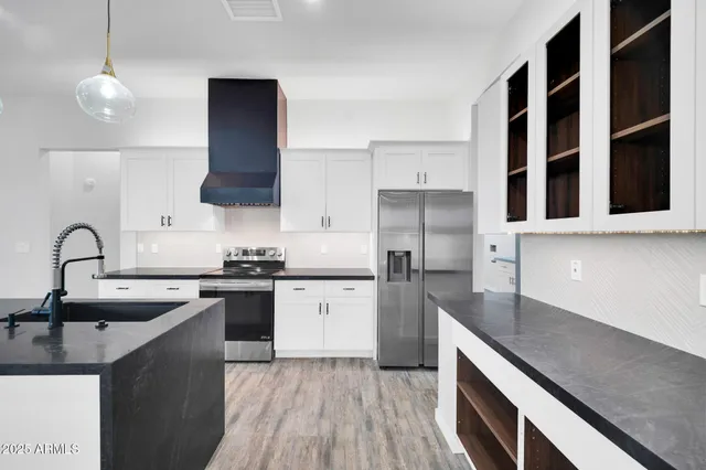 a kitchen with stainless steel appliances granite countertop a sink a stove and a refrigerator