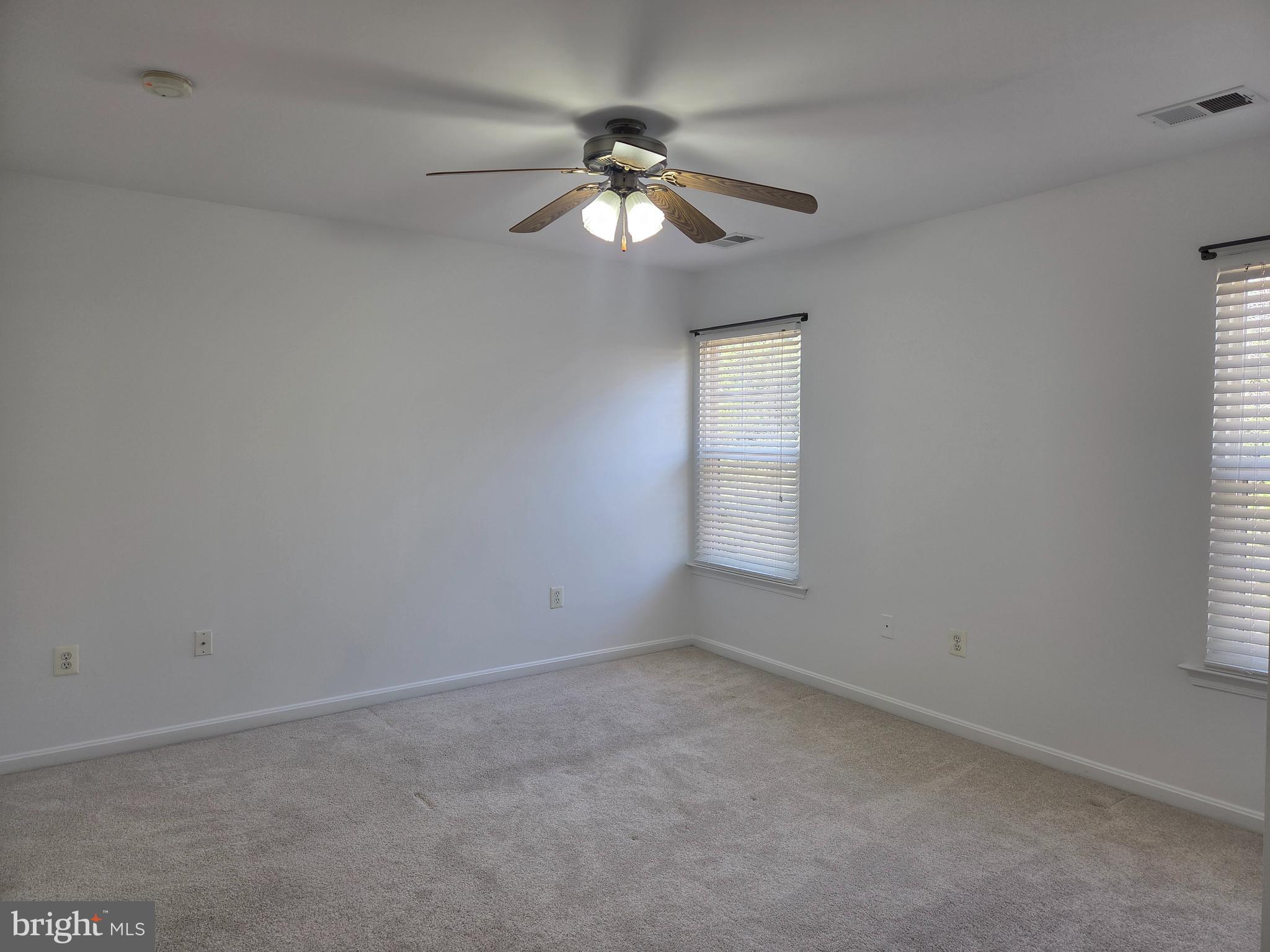 17381 Sligo Loop Dumfries, VA 22026 - Photo 15 of 35 an empty room with windows and chandelier fan
