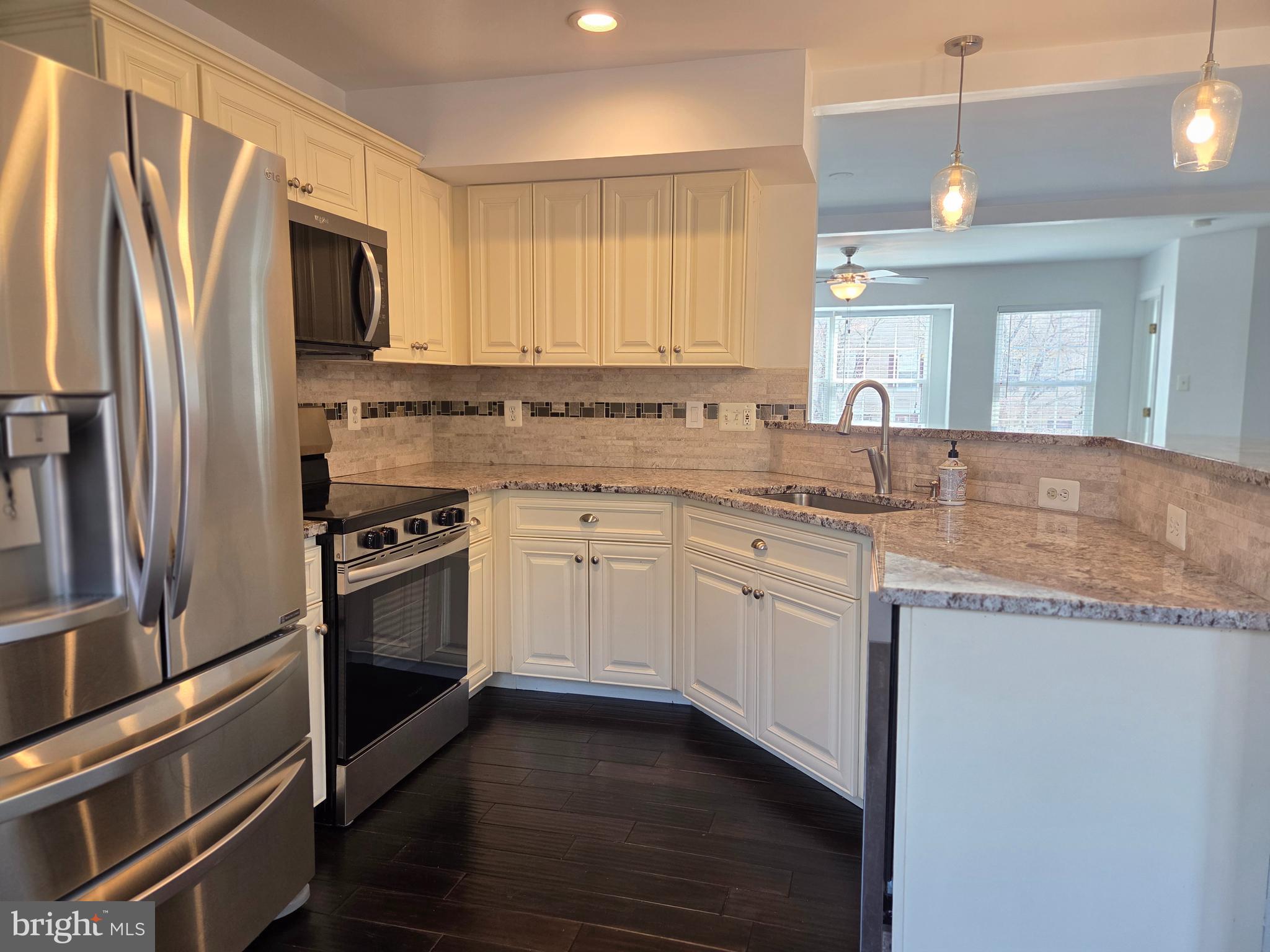 17381 Sligo Loop Dumfries, VA 22026 - Photo 4 of 35 a kitchen with granite countertop a sink stainless steel appliances and cabinets