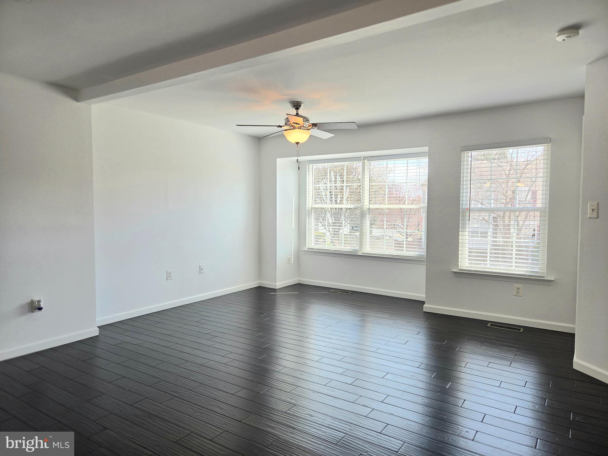 17381 Sligo Loop Dumfries, VA 22026 - Photo 10 of 35 an empty room with wooden floor chandelier fan and windows