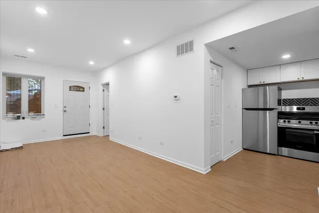 a view of an empty room with closet and a window