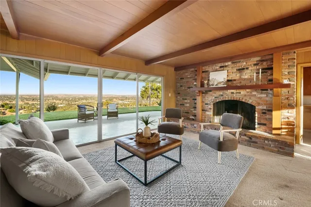 a living room with furniture fireplace and a floor to ceiling window