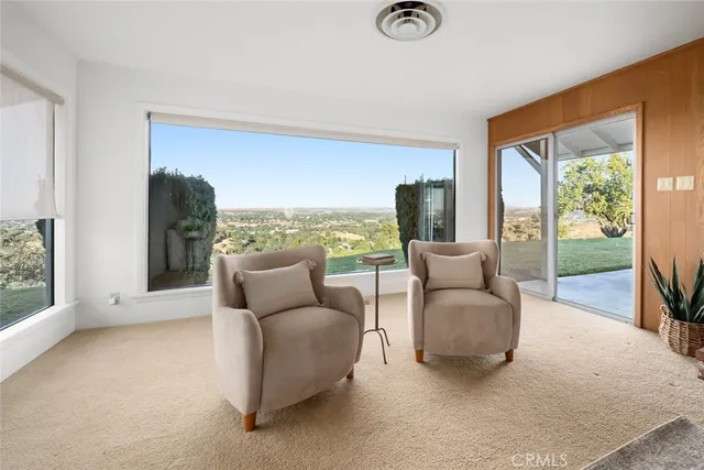 a living room with furniture and a floor to ceiling window