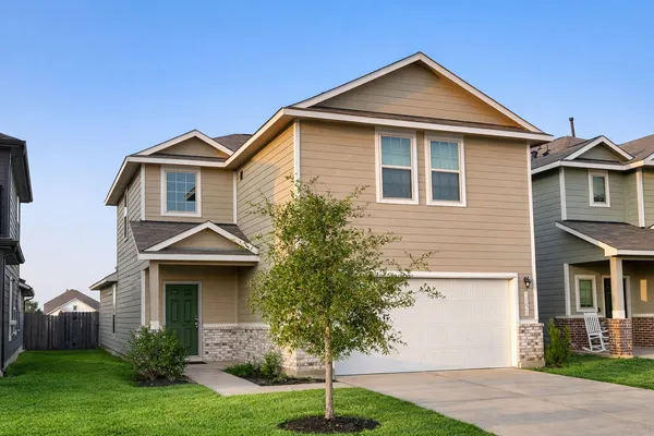 a front view of a house with a yard and trees