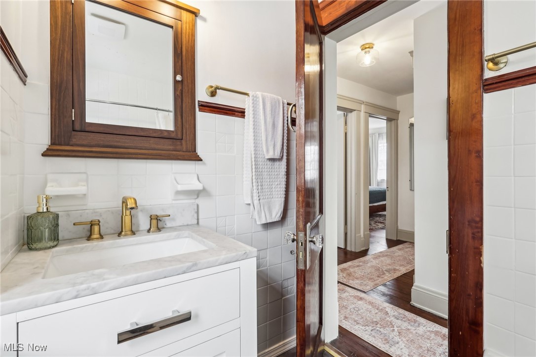 17901 Windward Road Cleveland, OH 44119 - Photo 19 of 33 Bathroom featuring vanity, wood-type flooring, and tile walls