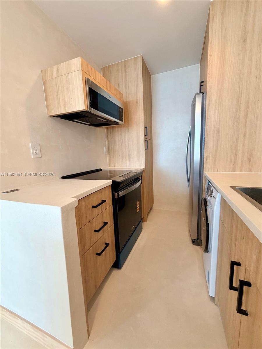 100 Lincoln Road, Unit 1241 Miami Beach, FL 33139 - Photo 5 of 18 a kitchen with stainless steel appliances white cabinets and a refrigerator