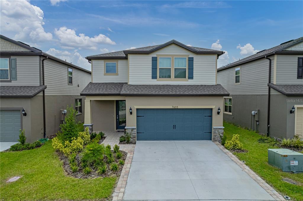 7603 Pool Compass Loop Wesley Chapel, FL 33545 - Photo 1 of 1 a front view of a house with a garden and garage