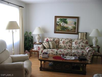 9177 Seville Road Fort Myers, FL 33967 - Photo 2 of 6 a living room with furniture and a lamp