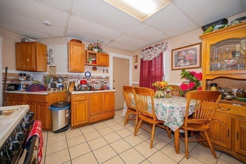 7 Cutler Street Worcester, MA 01604 - Photo 8 of 21 a kitchen with stainless steel appliances kitchen island granite countertop a table chairs in it and wooden floors