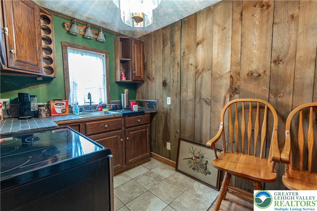 2485 Hieter Road Quakertown, PA 18951 - Photo 60 of 97 A cozy kitchen features rustic wood paneling and practical, dark wood cabinetry.