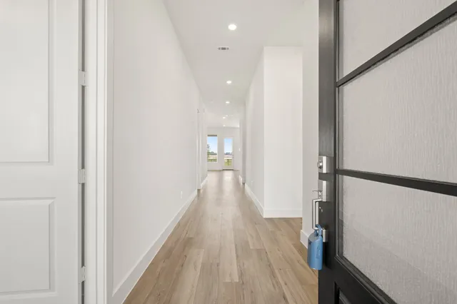 a view of a hallway with wooden floor and staircase