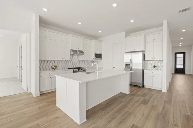 a kitchen with white cabinets and stainless steel appliances