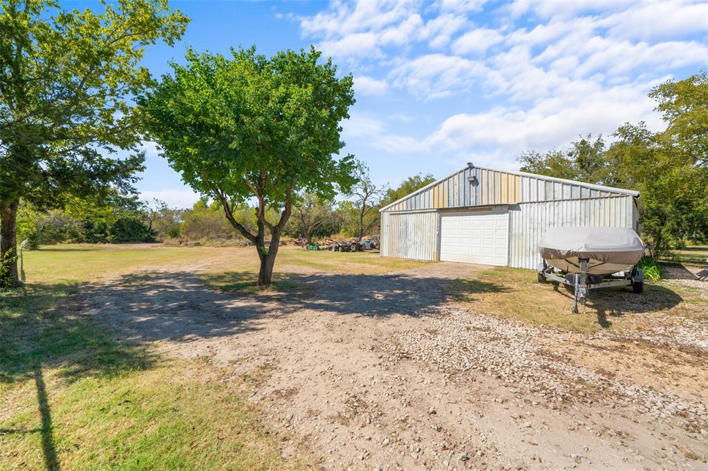 1724 Zagota Crossing Road Terrell, TX 75161 - Photo 5 of 22 View of grassy yard featuring a detached garage, an outbuilding, and dirt driveway
