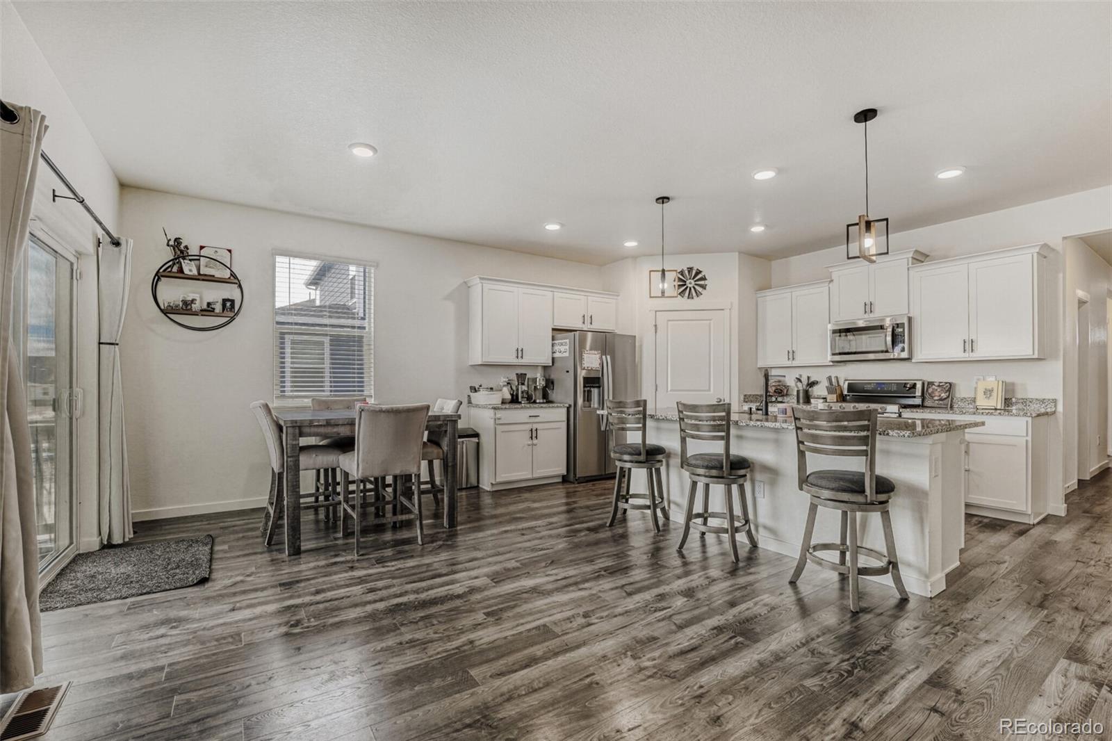 166 Racer Street Bennett, CO 80102 - Photo 13 of 44 a view of a dining room with furniture and wooden floor