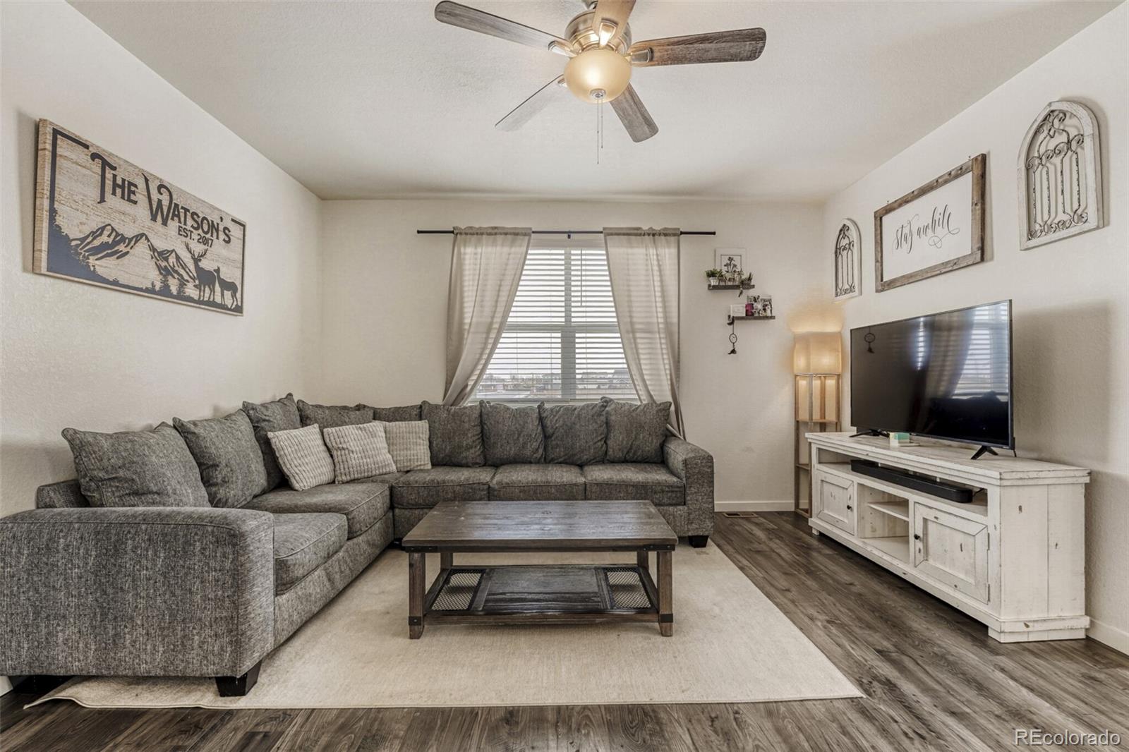 166 Racer Street Bennett, CO 80102 - Photo 18 of 44 a living room with furniture and a flat screen tv