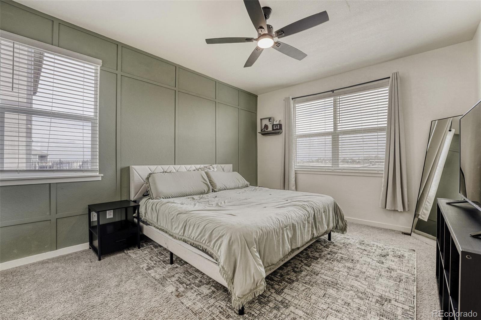 166 Racer Street Bennett, CO 80102 - Photo 20 of 44 a bedroom with a bed next to a window with a flat tv screen