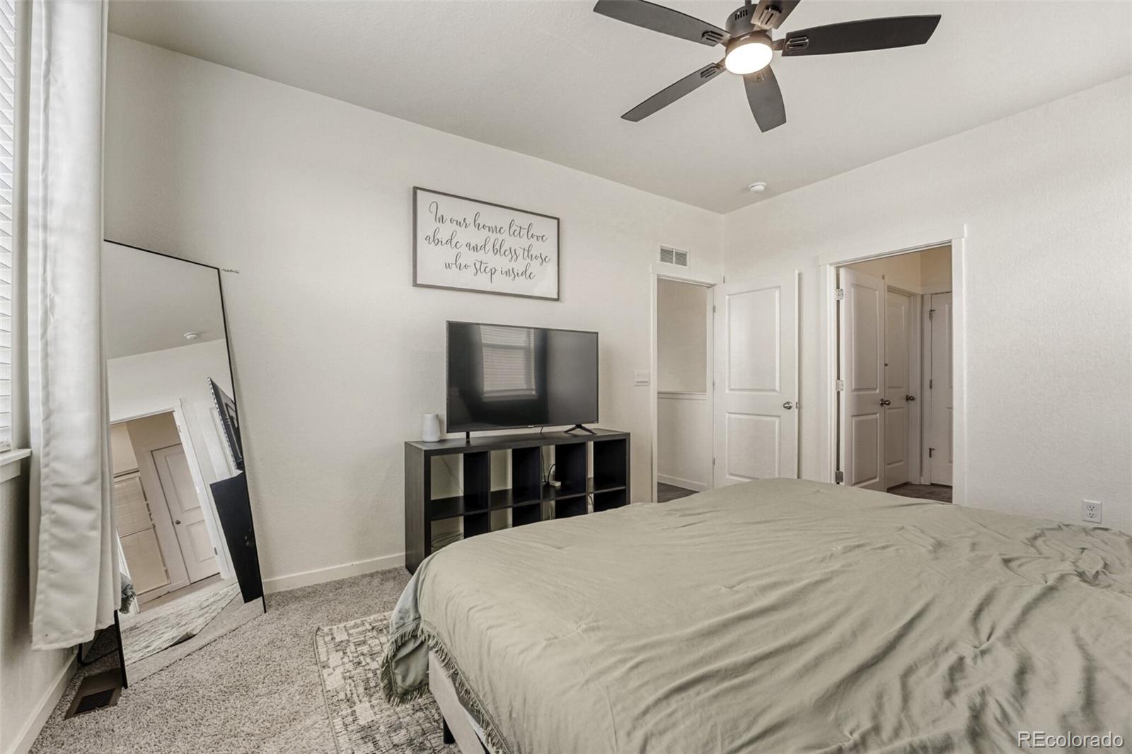 166 Racer Street Bennett, CO 80102 - Photo 22 of 44 a bedroom with a bed and a flat screen tv