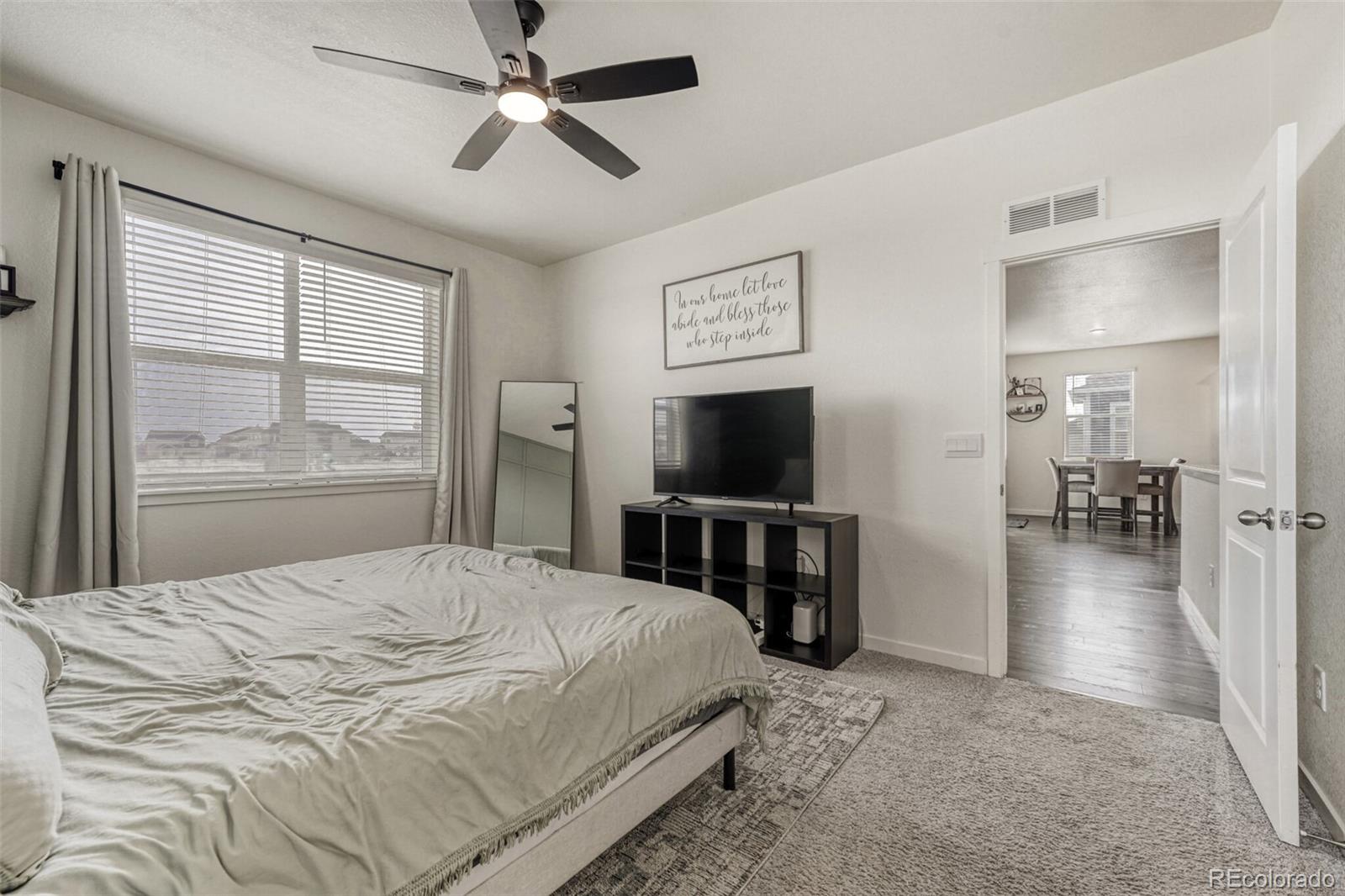 166 Racer Street Bennett, CO 80102 - Photo 23 of 44 a bedroom with a bed and a flat screen tv
