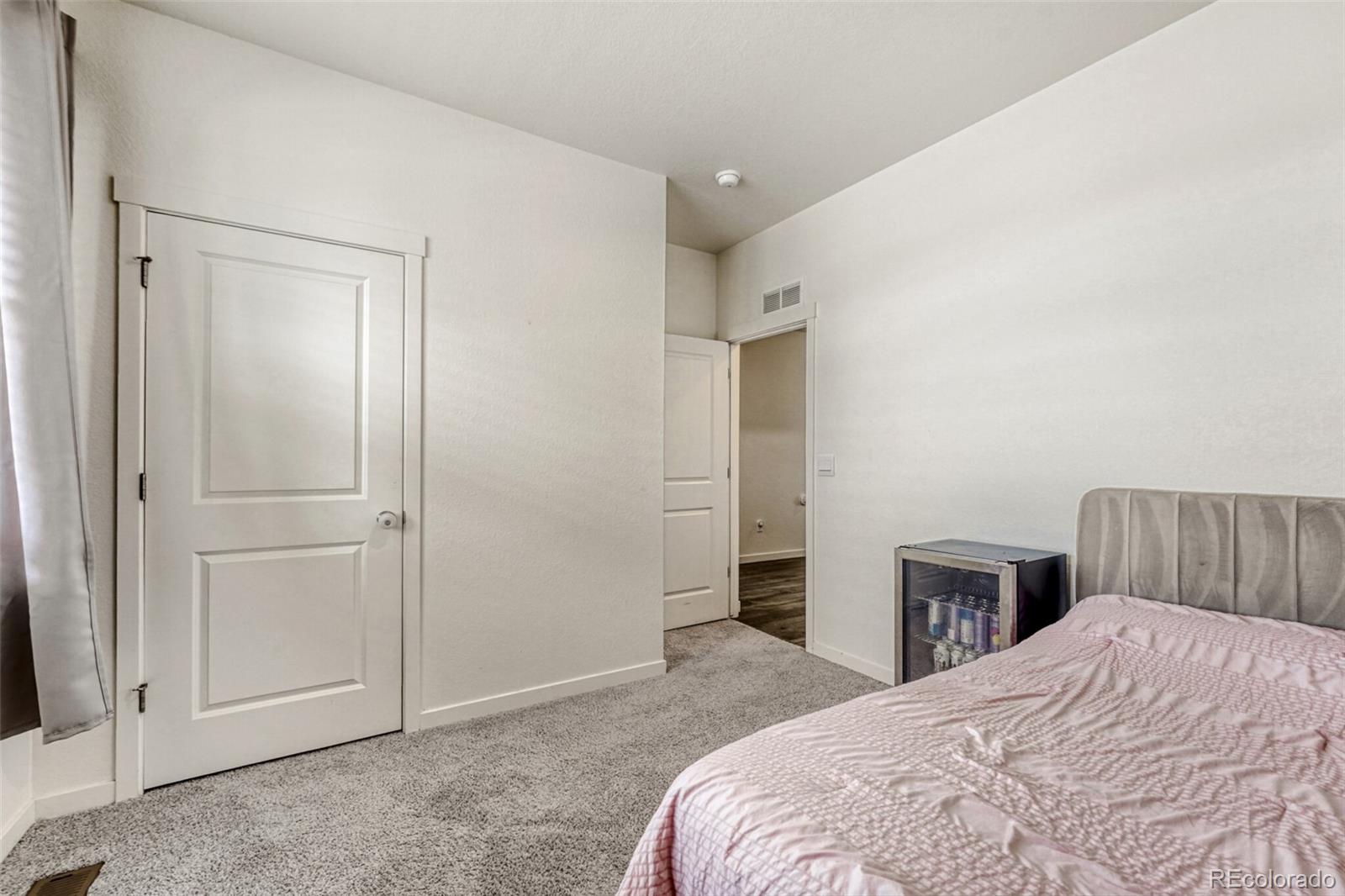 166 Racer Street Bennett, CO 80102 - Photo 27 of 44 a bedroom with a bed and wooden floor