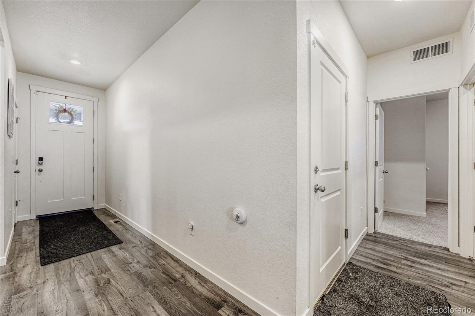 166 Racer Street Bennett, CO 80102 - Photo 6 of 44 a view of a hallway with wooden floor and a bathroom