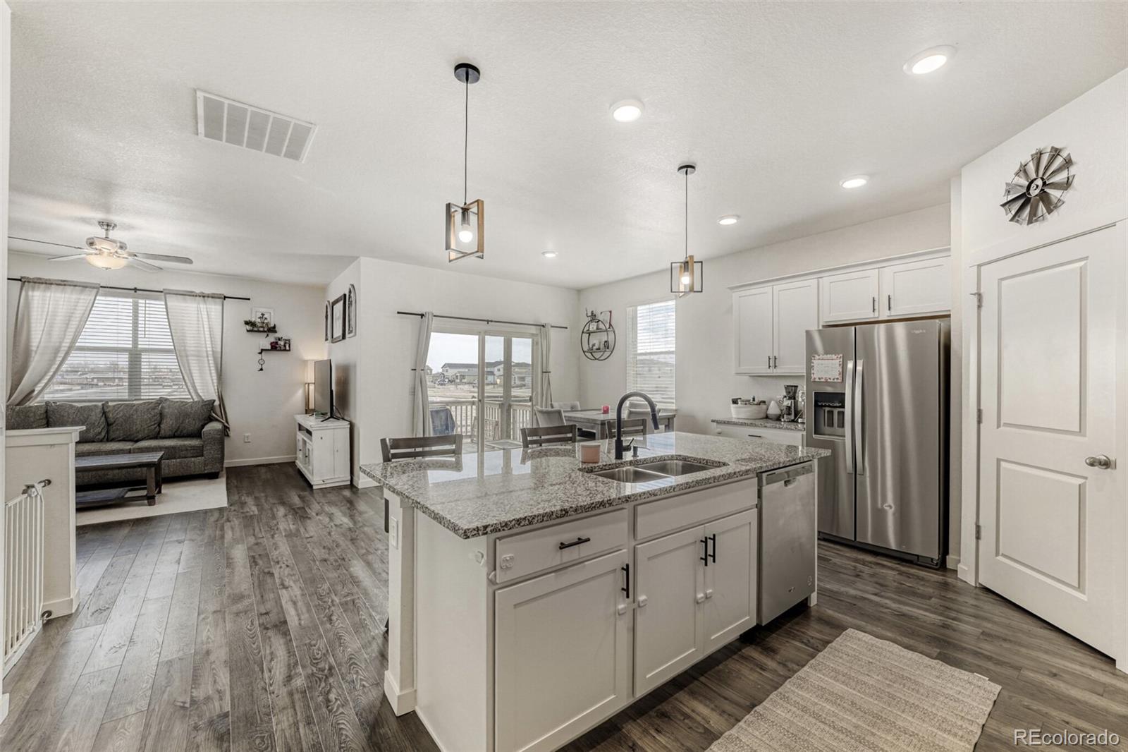 166 Racer Street Bennett, CO 80102 - Photo 7 of 44 a kitchen with sink refrigerator and outdoor view
