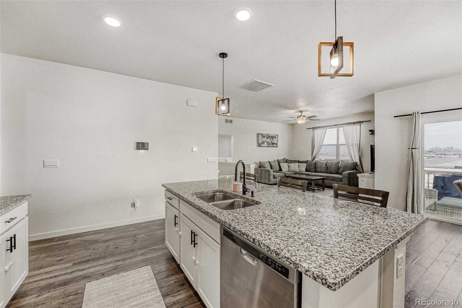 166 Racer Street Bennett, CO 80102 - Photo 8 of 44 a kitchen with stainless steel appliances granite countertop a sink stove and cabinets