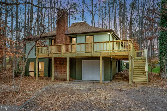 a view of a house with a yard and large tree