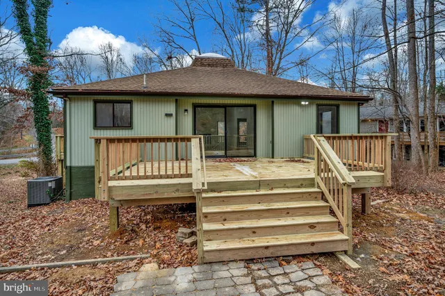 a view of a house with a deck and a yard