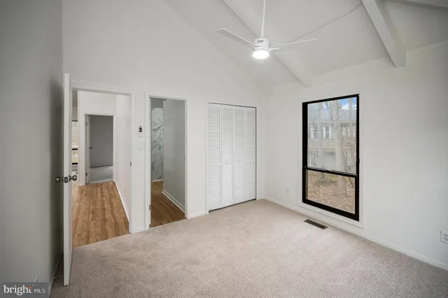 an empty room with closet and windows