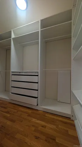 a view of walk in closet with empty racks