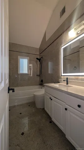 a bathroom with a double vanity sink a mirror and a bathtub